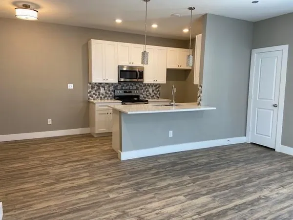 a view of kitchen with microwave stove refrigerator and cabinets