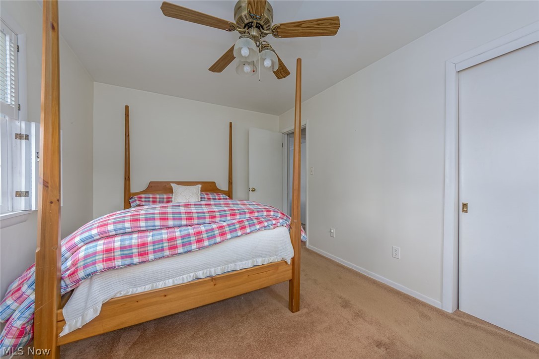 3331 Boyne Road Barberton, OH 44203 - Photo 10 of 22 The bedroom features a ceiling fan, sliding doors to the closet, and hardwood floors under the carpet.