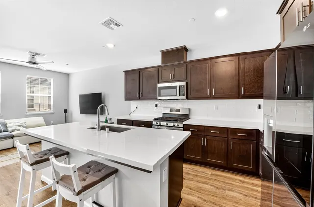 a kitchen with a stove a sink a microwave a refrigerator and cabinets