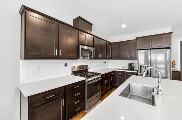 a kitchen with stainless steel appliances granite countertop a sink stove and refrigerator