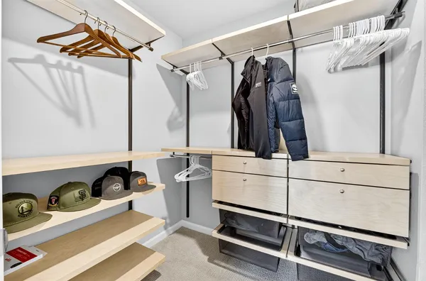 a view of walk in closet with clothes and shoes