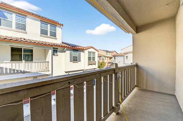 a view of a house with a balcony and wooden floor