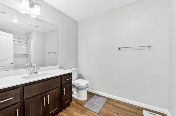 a bathroom with a sink a toilet a mirror and vanity
