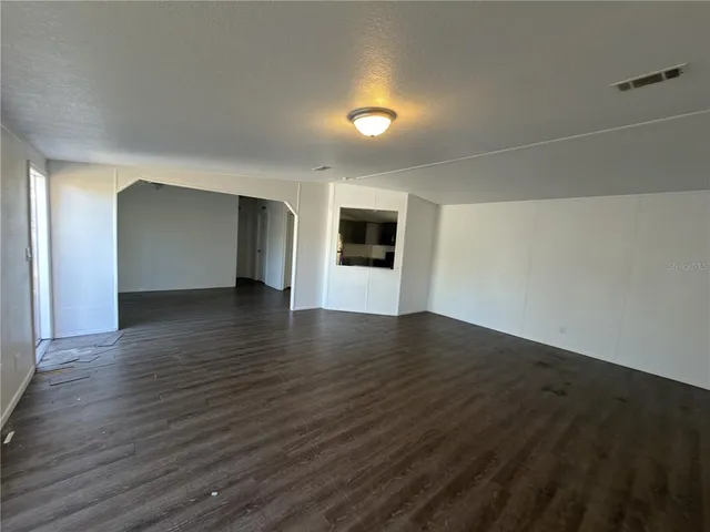 a view of a big room with wooden floor and fire place