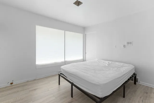 a bed sitting in a bedroom next to a window