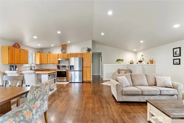 a living room kitchen with furniture and a wooden floor