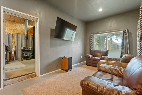 a living room with furniture a flat screen tv and a floor to ceiling window