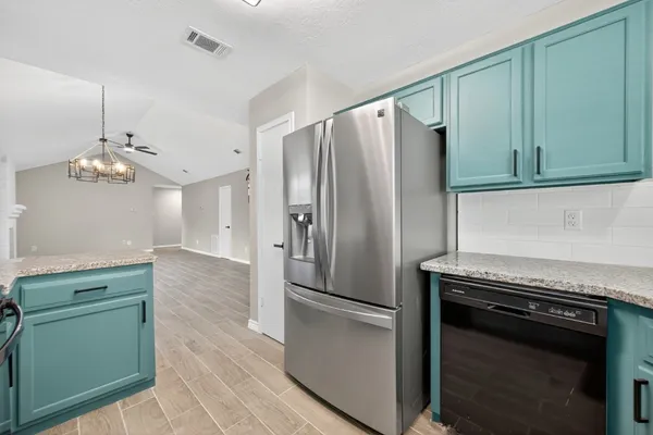 a kitchen with granite countertop stainless steel appliances and wooden cabinets