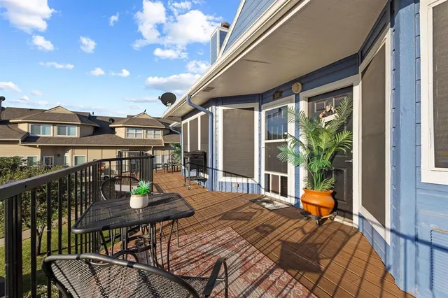 a view of balcony with dining table and chairs