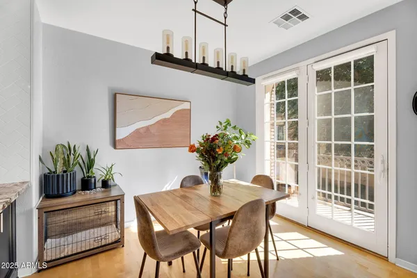 a dining room with furniture potted plants and wooden floor