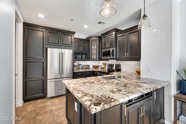 a kitchen with kitchen island a refrigerator a stove and a sink