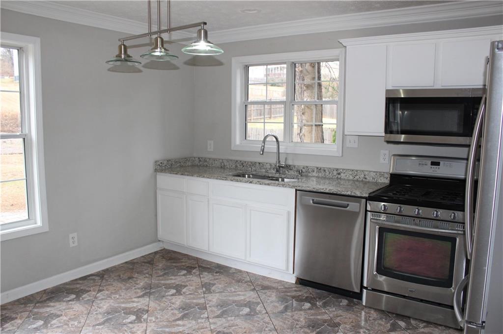 1250 Springmont Court Lawrenceville, GA 30043 - Photo 3 of 16 a kitchen with a stove and a microwave