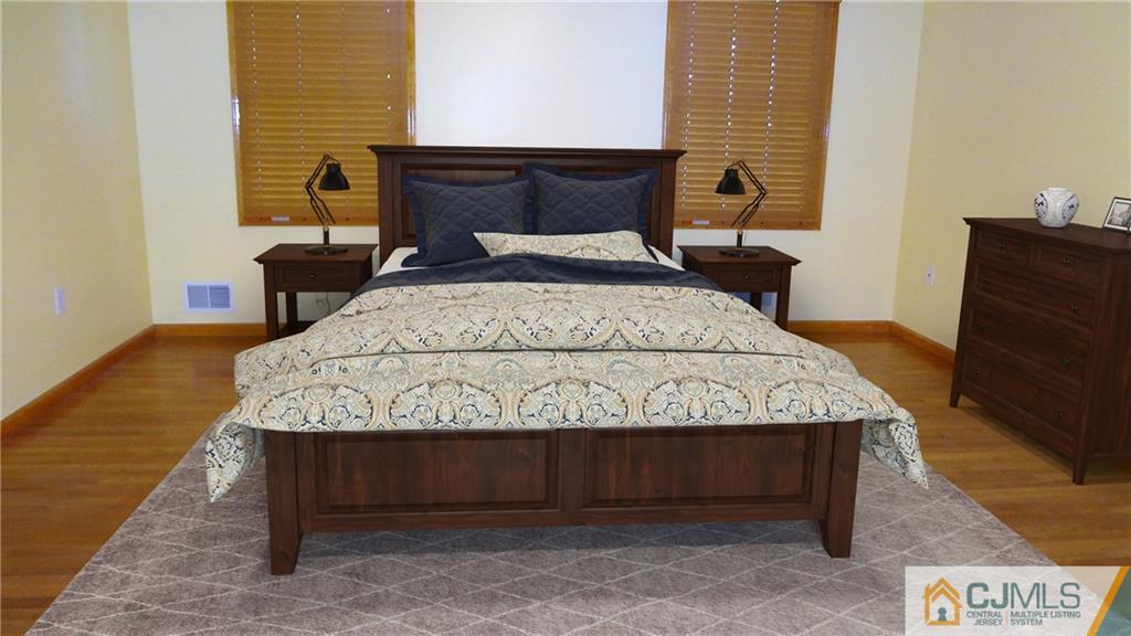 5 Verdi Road Monroe Township, NJ 08831 - Photo 14 of 25 a bed sitting in a bedroom next to a window with wooden floor