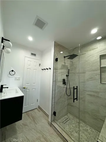 a bathroom with a double vanity sink toilet and shower