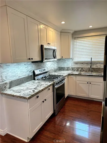 a kitchen with stainless steel appliances granite countertop a sink stove and cabinets
