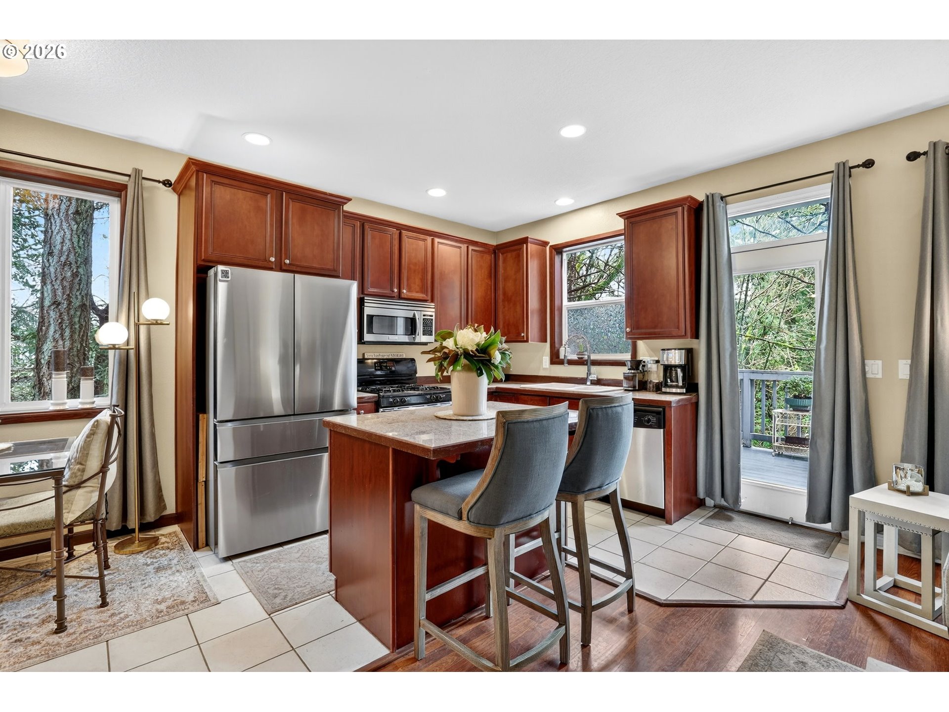 810 East 9th Street, Unit D13 Newberg, OR 97132 - Photo 16 of 42 a kitchen with stainless steel appliances a refrigerator a stove a sink dishwasher and a dining table with wooden floor