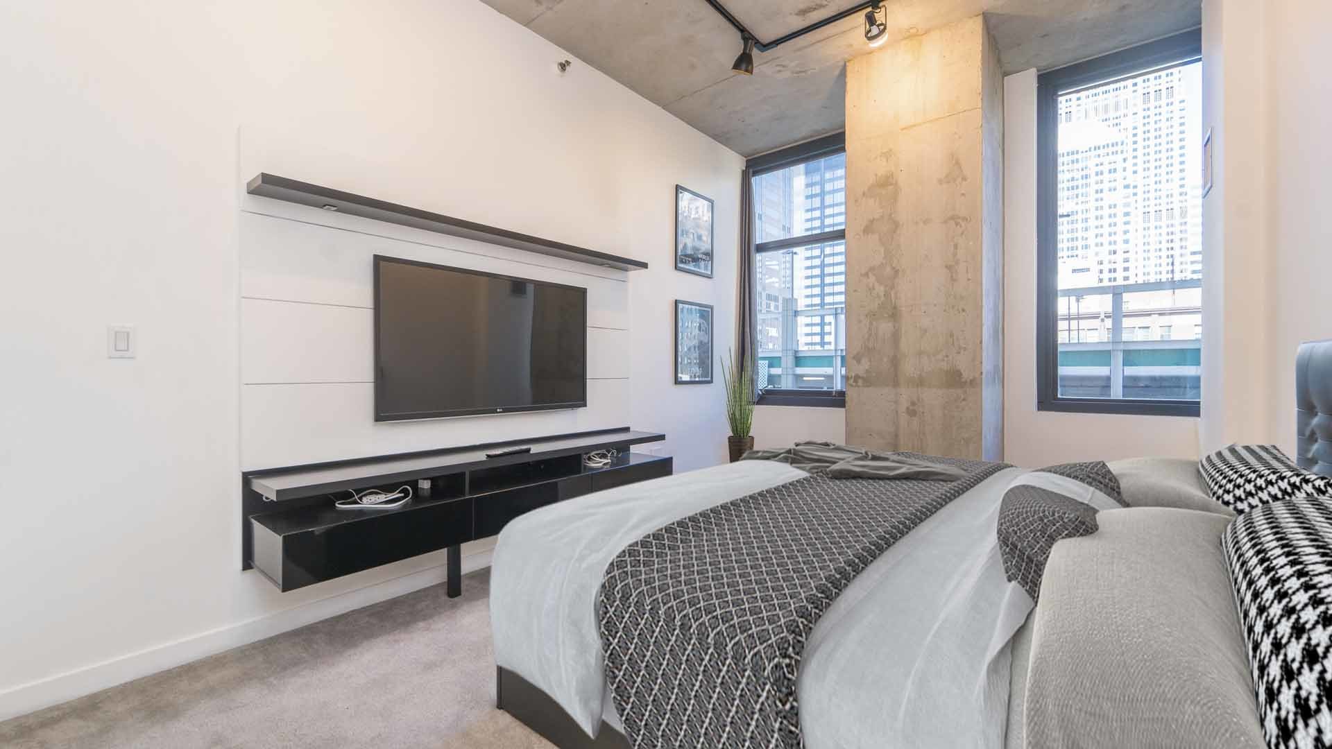 235 West Van Buren Street, Unit 1519 Chicago, IL 60607 - Photo 5 of 10 a bedroom with a bed and a flat screen tv