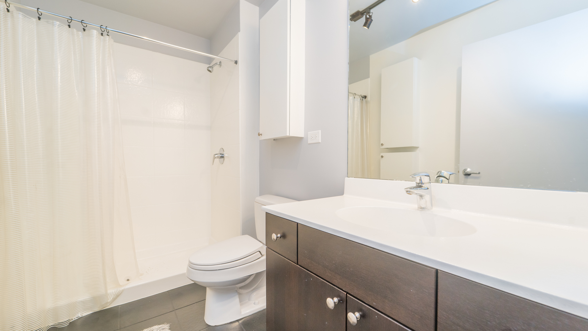 235 West Van Buren Street, Unit 1519 Chicago, IL 60607 - Photo 7 of 10 a bathroom with a sink a toilet and shower