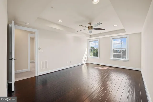 an empty room with a ceiling fan and a window