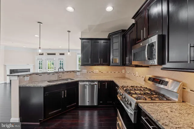 a kitchen with stainless steel appliances granite countertop a stove a sink and a refrigerator