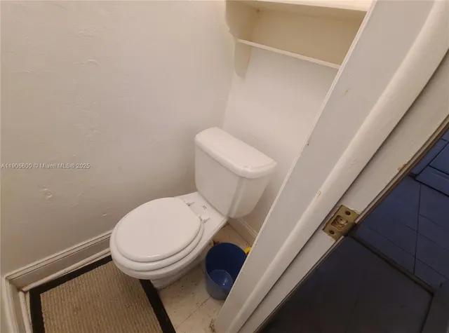 a white toilet sitting next to a shower