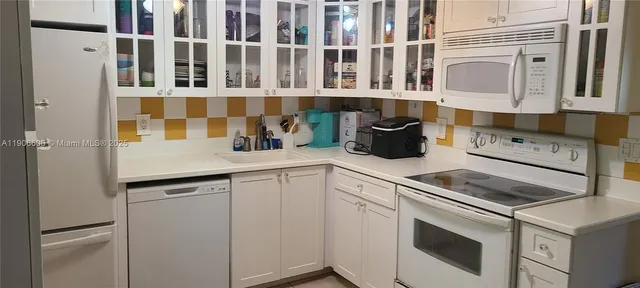 a kitchen with stainless steel appliances granite countertop white cabinets and window