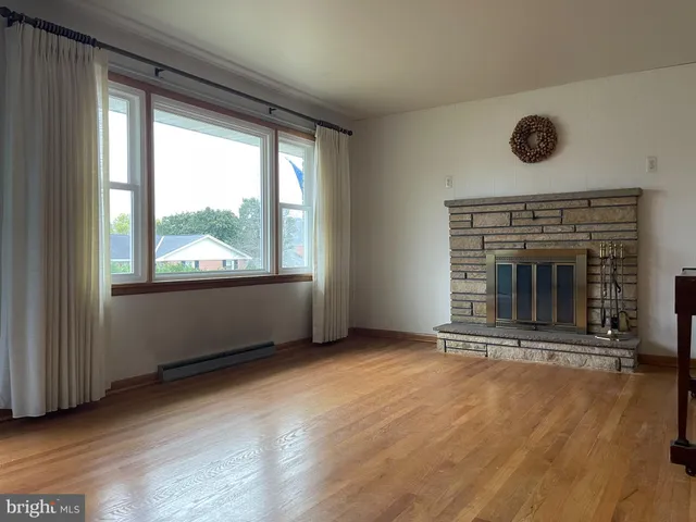 an empty room with wooden floor and fireplace
