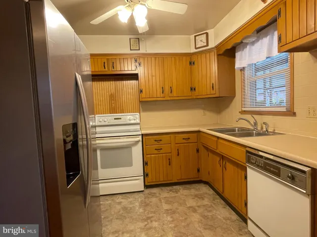 a kitchen with a refrigerator sink and cabinets