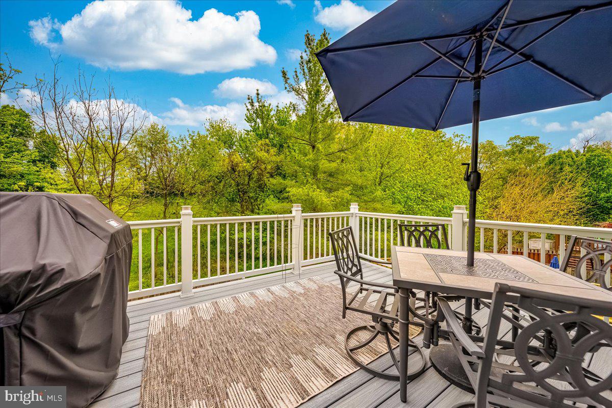 10109 Shelldrake Circle Damascus, MD 20872 - Photo 36 of 47 a view of a wooden deck with furniture and umbrella