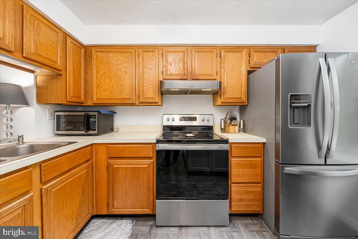 10109 Shelldrake Circle Damascus, MD 20872 - Photo 10 of 47 a kitchen with stainless steel appliances granite countertop a refrigerator a stove and a sink