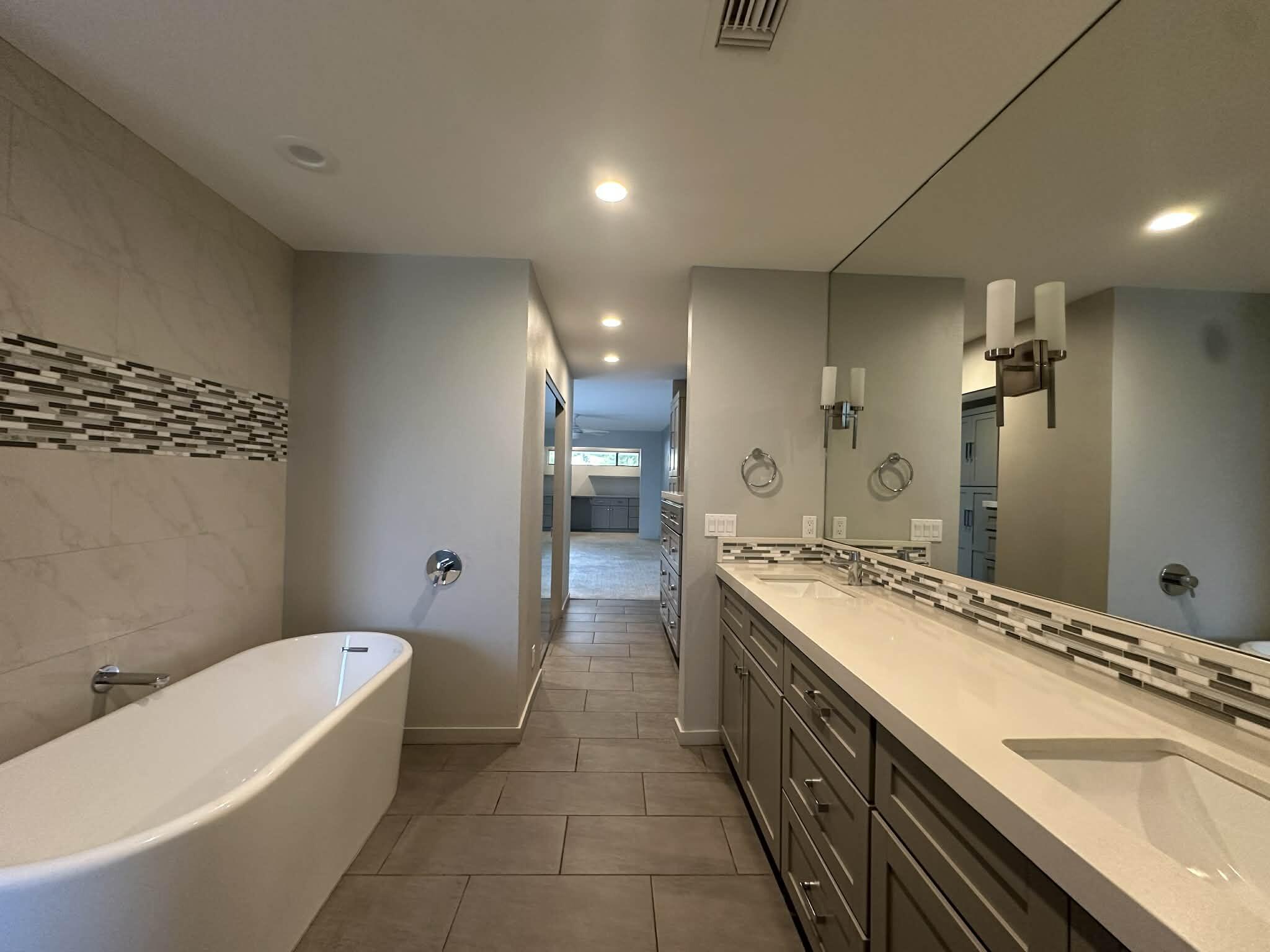 4 Saturn Circle Rancho Mirage, CA 92270 - Photo 30 of 32 a bathroom with a granite countertop sink a toilet a mirror and bathtub