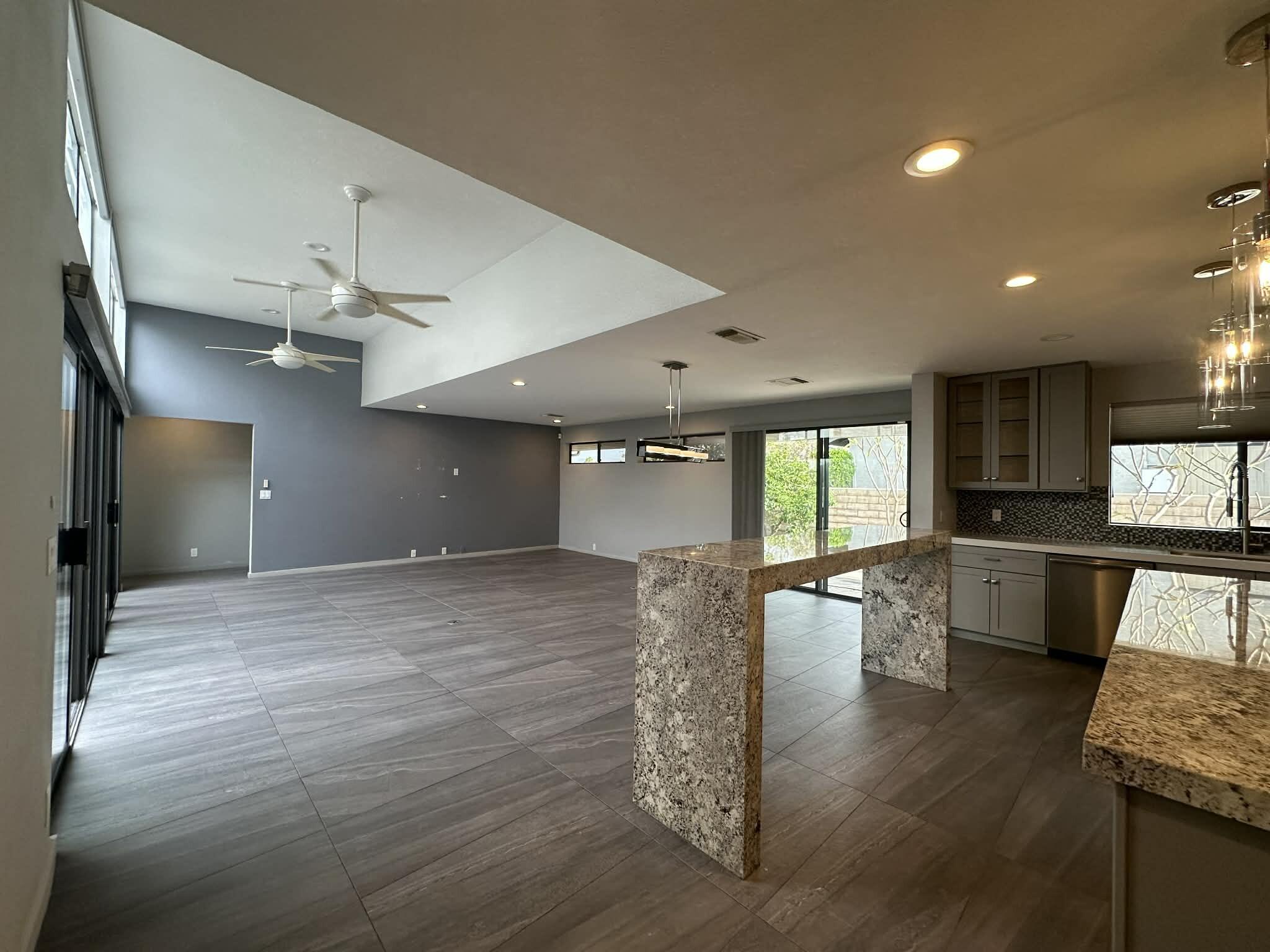 4 Saturn Circle Rancho Mirage, CA 92270 - Photo 8 of 32 a view of a kitchen and dining room with a table wooden floor and chandelier