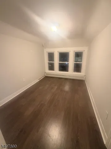 a view of a livingroom with wooden floor and windows