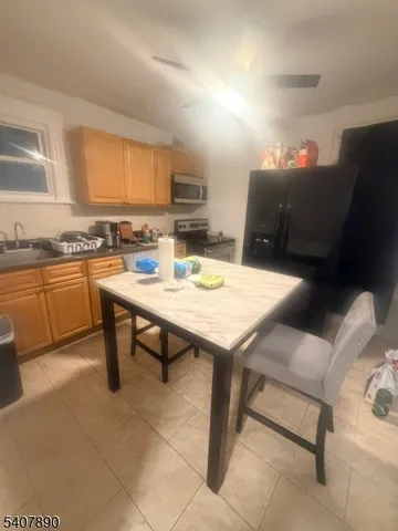 a view of kitchen island with stainless steel appliances refrigerator sink and stove