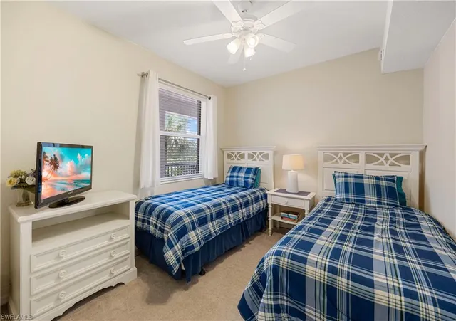 a bedroom with two beds and a window