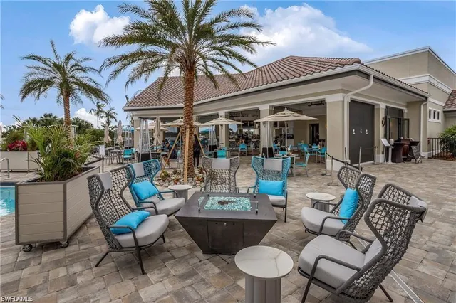 a view of a patio with couches table and chairs potted plants and palm tree