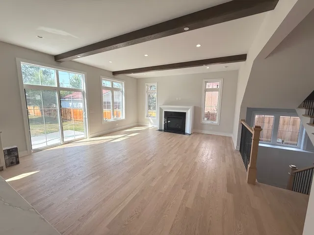 an empty room with wooden floor and a fireplace