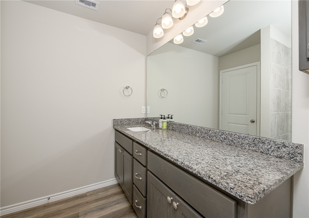 2166 Chief Street Bryan, TX 77807 - Photo 13 of 18 a bathroom with a granite countertop sink and a mirror