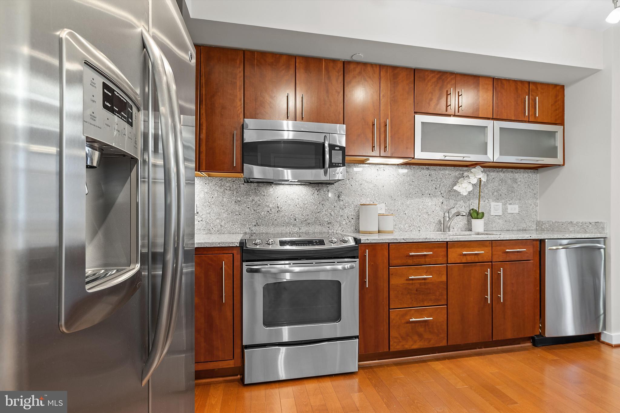 1025 First Street Southeast, Unit 1114 Washington, DC 20003 - Photo 2 of 23 a kitchen with stainless steel appliances granite countertop a stove a microwave and a sink