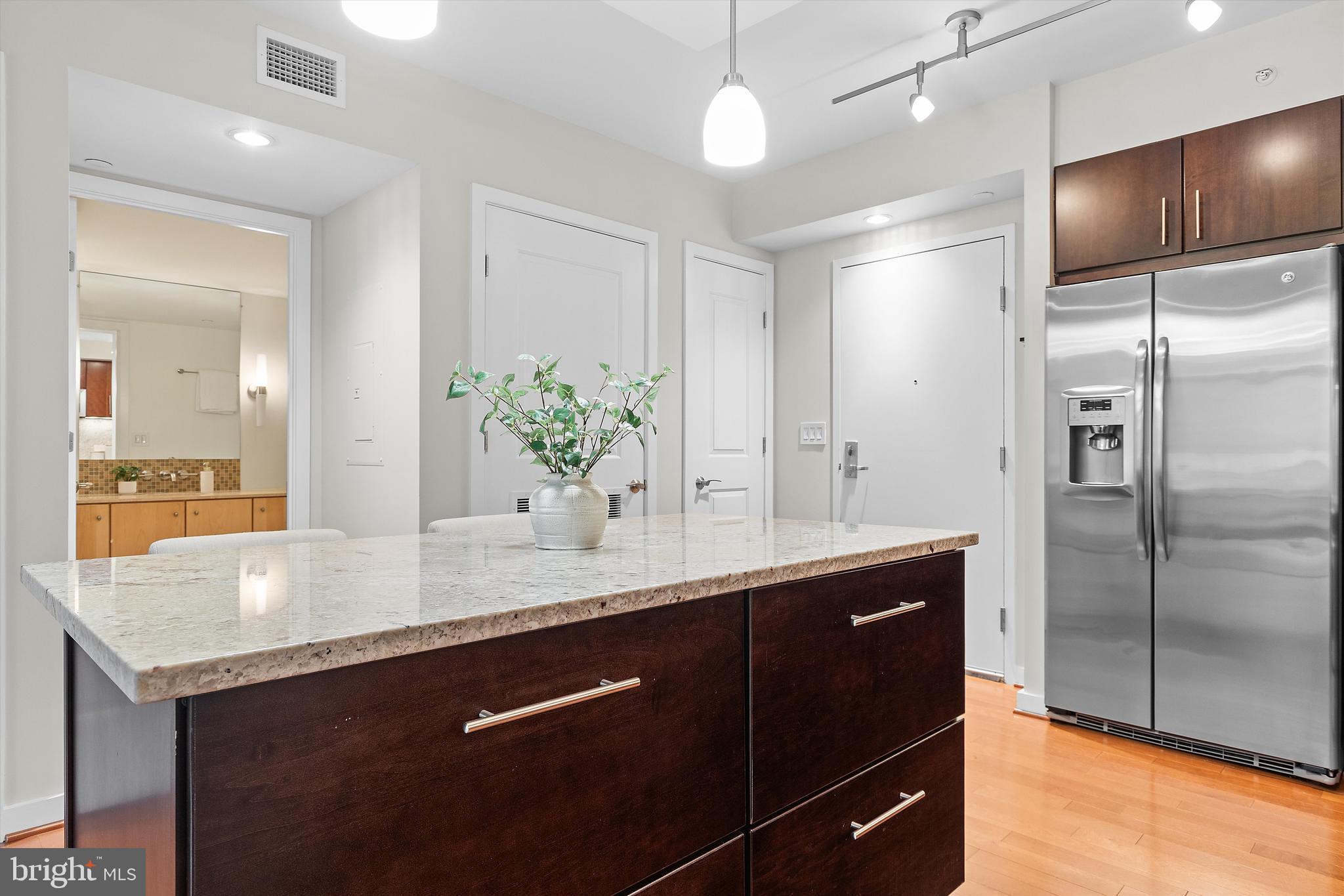 1025 First Street Southeast, Unit 1114 Washington, DC 20003 - Photo 5 of 23 a kitchen with stainless steel appliances granite countertop a sink and a refrigerator