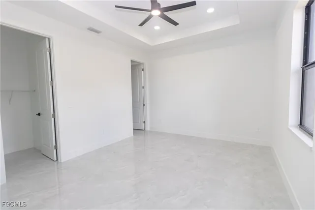 an empty room with a ceiling fan and a window