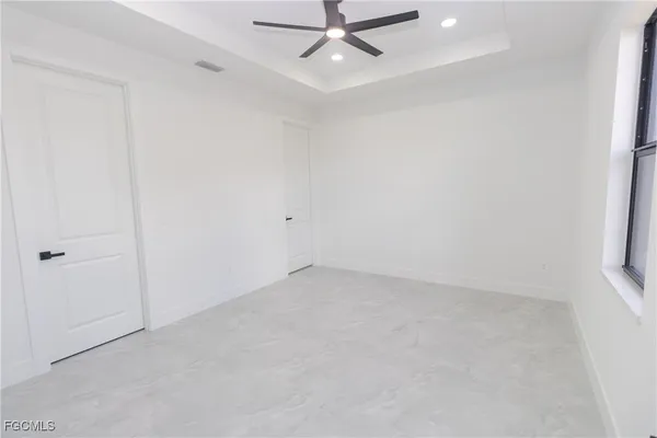 an empty room with a window and a fan