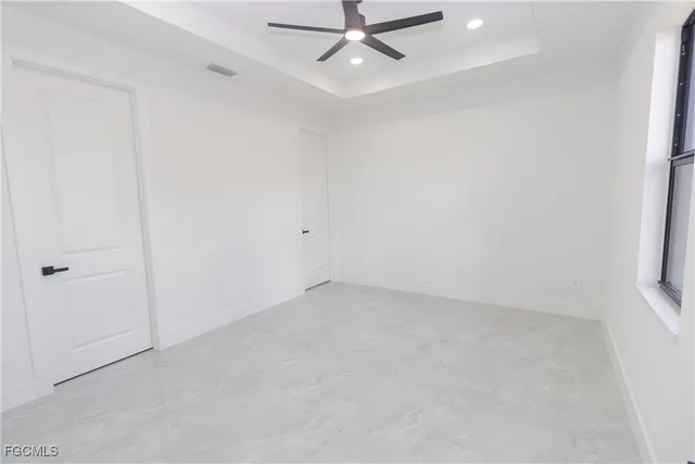 an empty room with a window and a fan