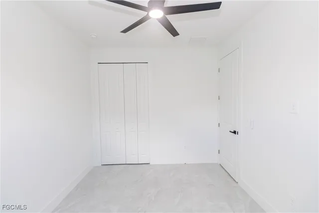 an empty room with a ceiling fan and wooden floor