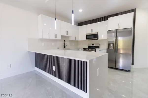 a kitchen with stainless steel appliances a refrigerator sink and microwave