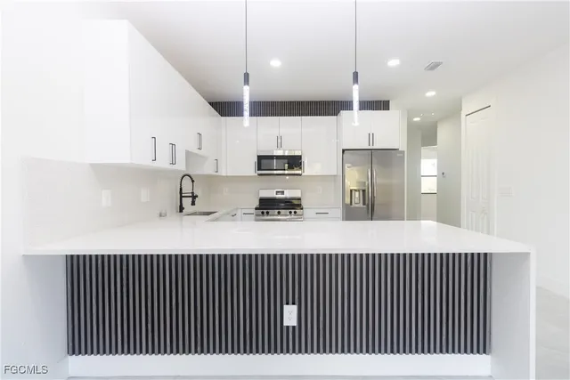 a kitchen with stainless steel appliances granite countertop a sink a refrigerator and a cabinets