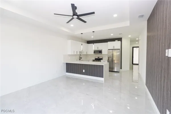 a large white kitchen with a refrigerator a sink dishwasher and a stove