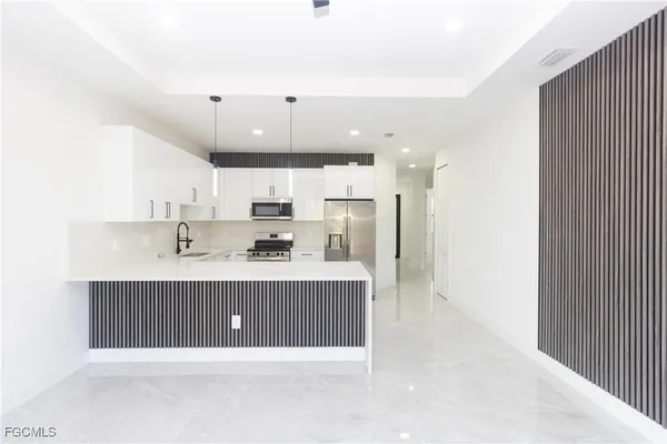 a open kitchen with kitchen island a sink stainless steel appliances and cabinets