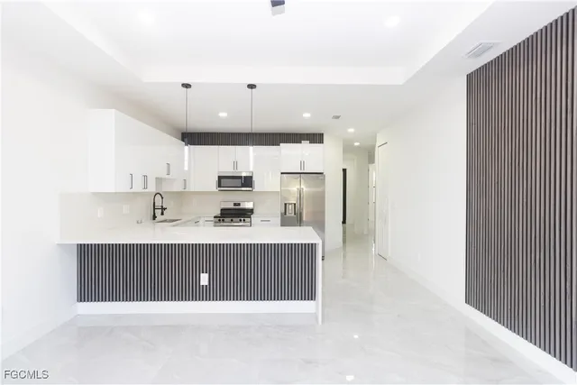 a open kitchen with kitchen island a sink stainless steel appliances and cabinets