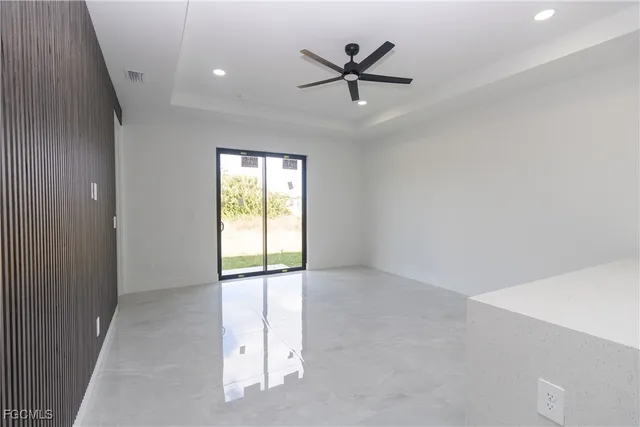 an empty room with windows and fan